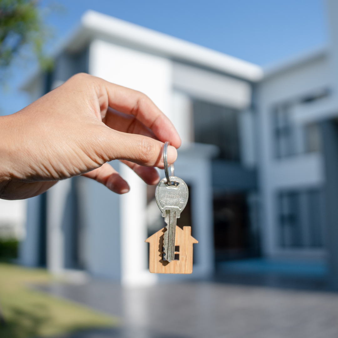 Ramneet holding a home key, symbolizing ownership or a successful real estate deal.